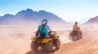 Marsa Alam Desert Safari adventure driving quad bikes through golden sand dunes.